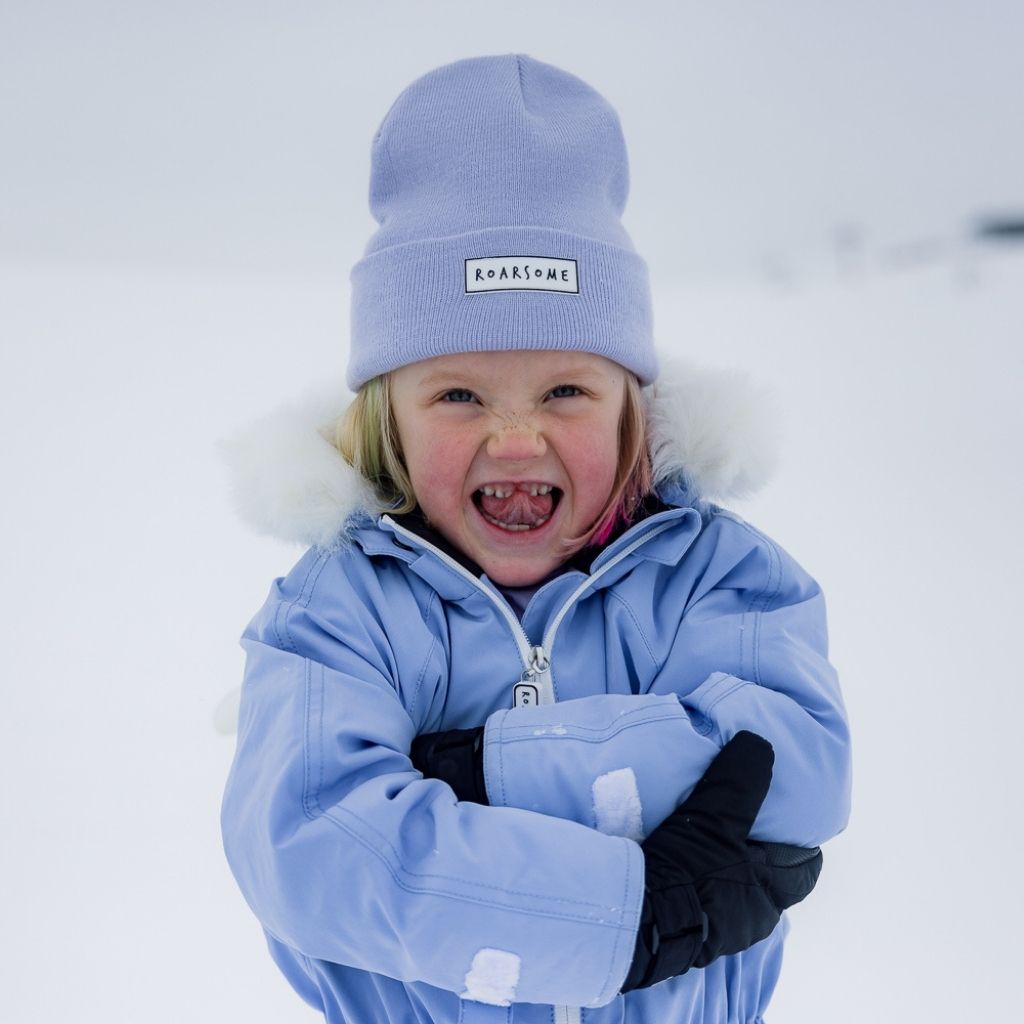 Little girl in the snow wearing Heather Beanie in Purple from Roarsome