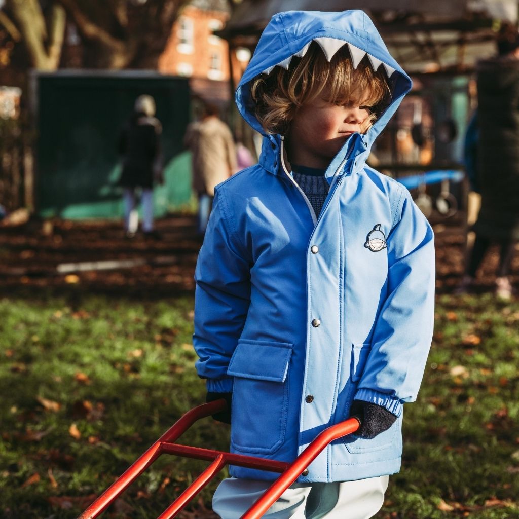Little boy wearing the Everyday Raincoat in Reef the Shark Blue from Roarsome