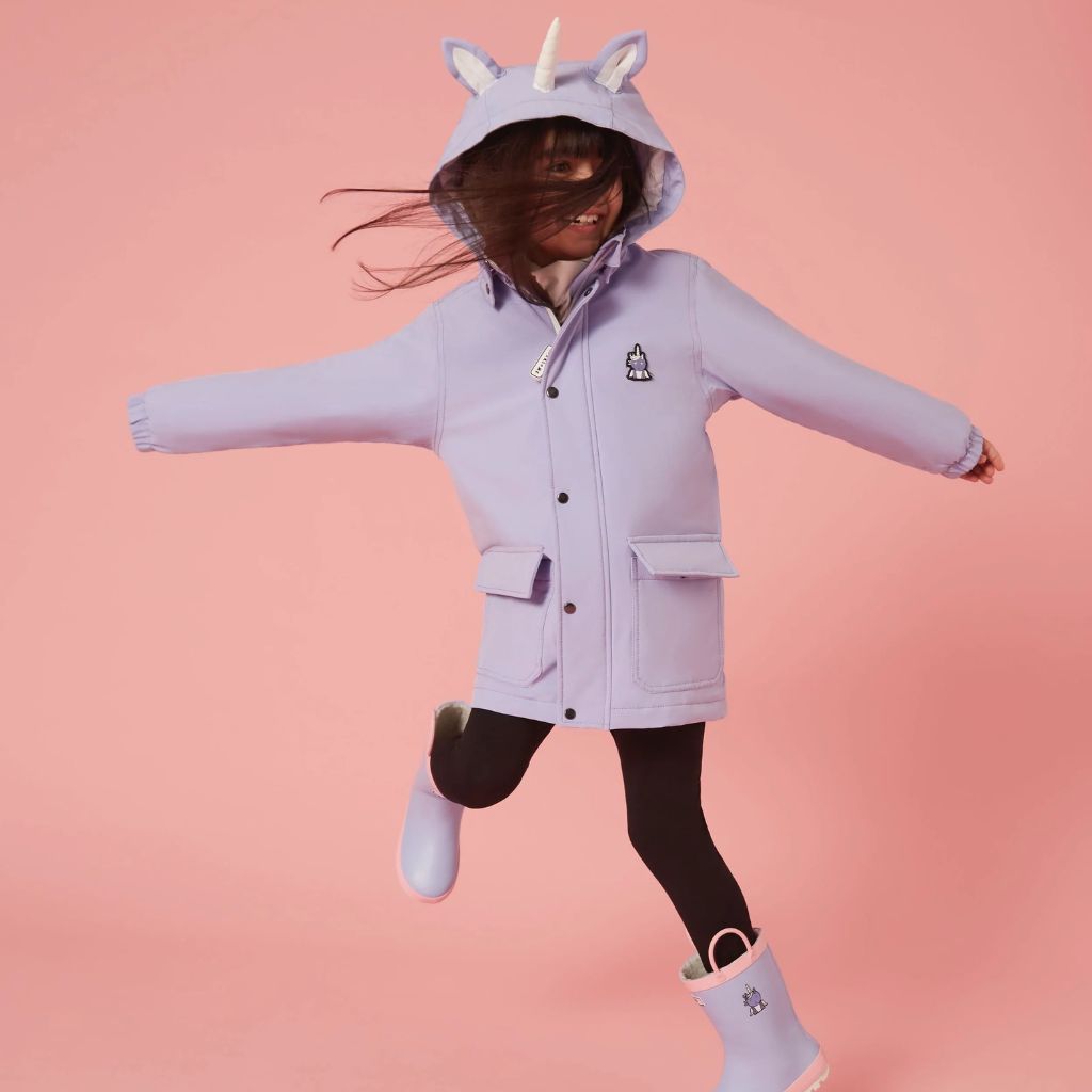 Little girl wearing the Everyday Raincoat in Sparkle the Unicorn Purple from Roarsome