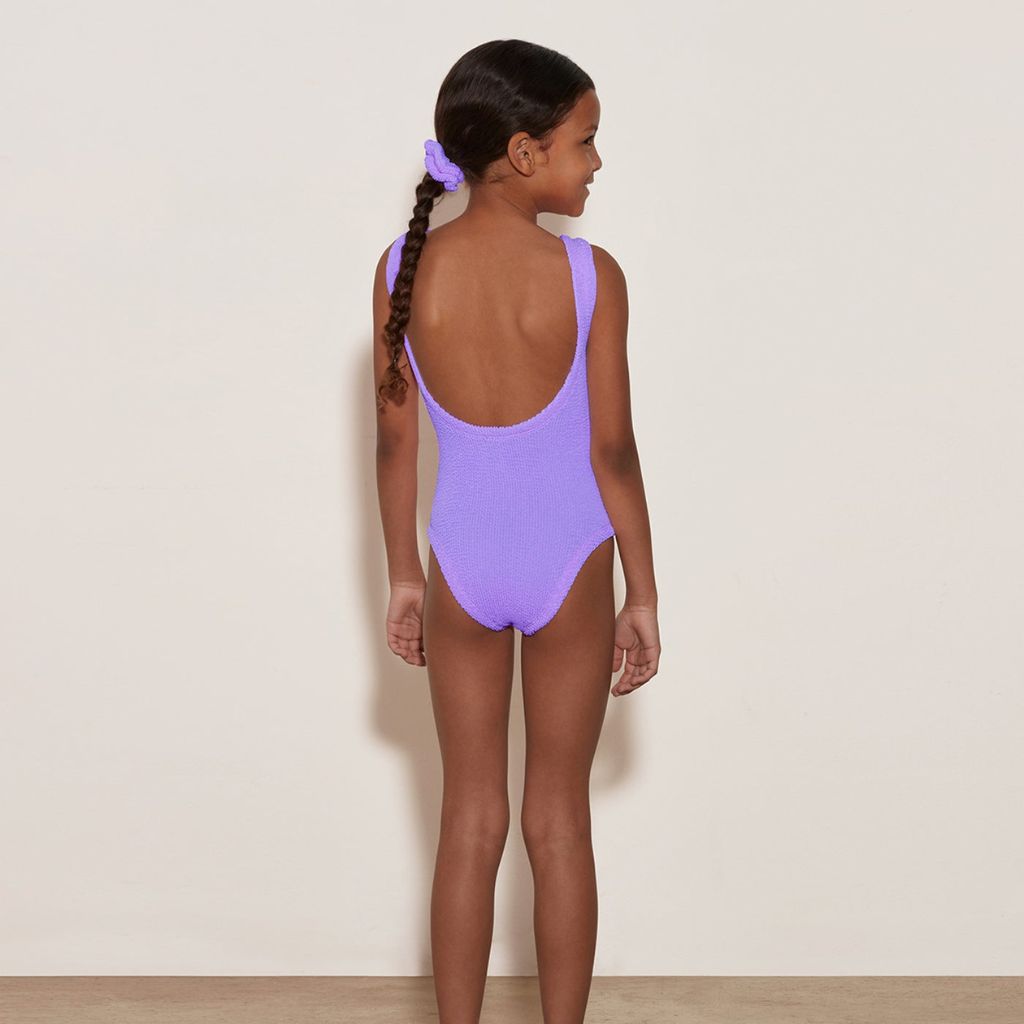 Little girl from the back wearing the Hunza G Baby Classic Swimsuit in Lilac for girls aged 3 - 6 years