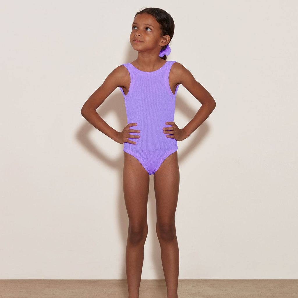 Little girl from the front wearing the Hunza G Baby Classic Swimsuit in Lilac for girls aged 3 - 6 years