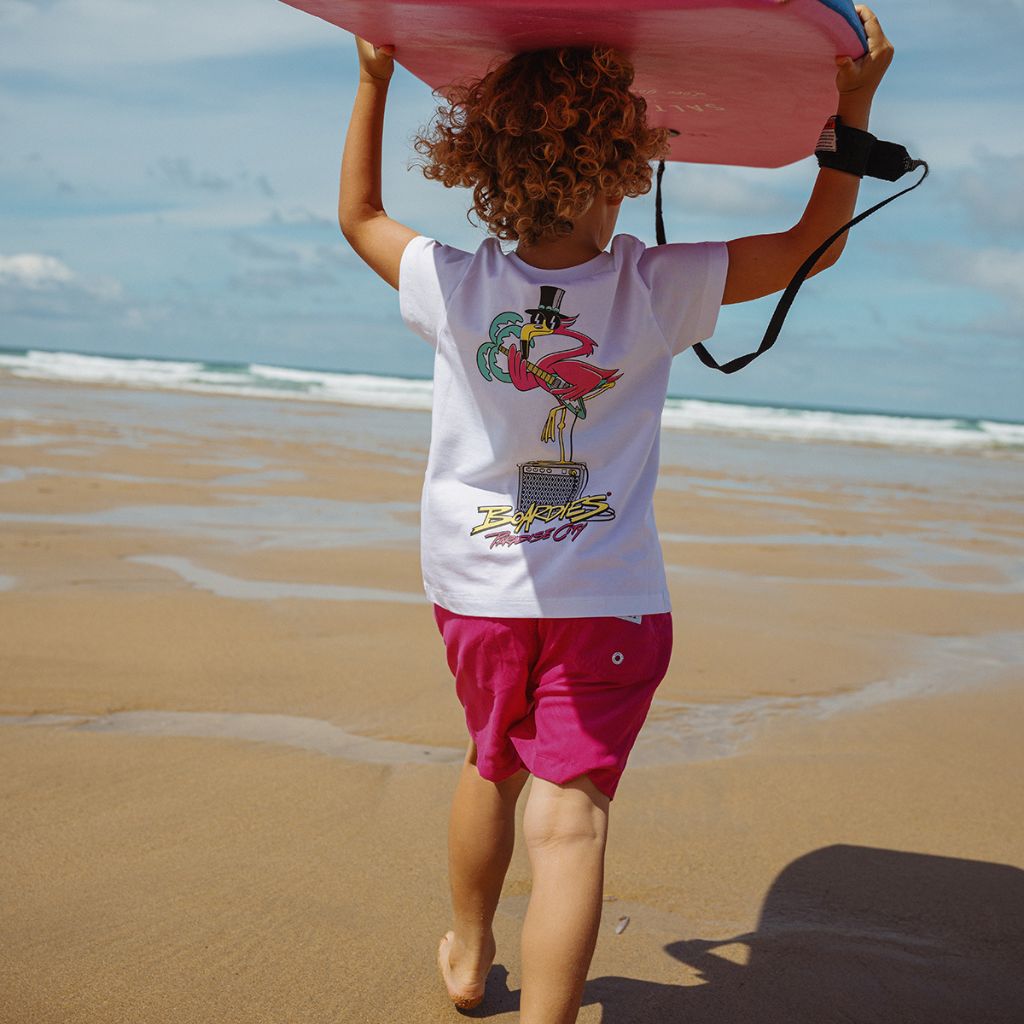 Little boy running to the sea wearing the Boardies Las Coloradas Kids Swim Shorts