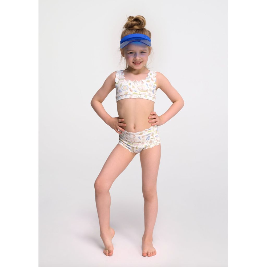 Little girl from the front wearing the Marysia Bumby Palm Springs Bikini Top and Santa Monica Bikini Bottoms in Cameo Print 1