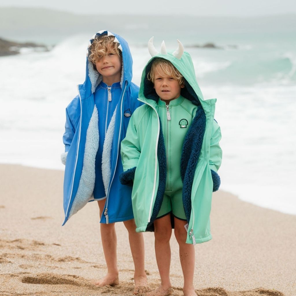 Little boys wearing the Roarsome outdoor chnaging dry robes in Spike the Dinosaur and Reef the Shark colourways