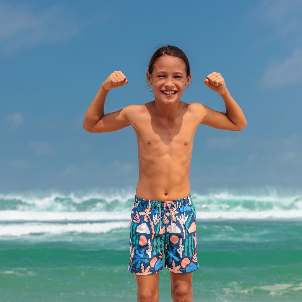 Little boy by the sea wearing the FBoardies Palm Spring Kids Swim Shorts