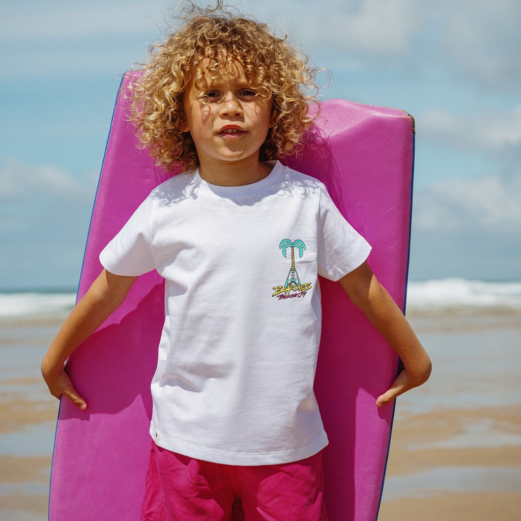 Little boy carrying a boogie board and wearing the Boardies Paradise City Kids T-Shirt