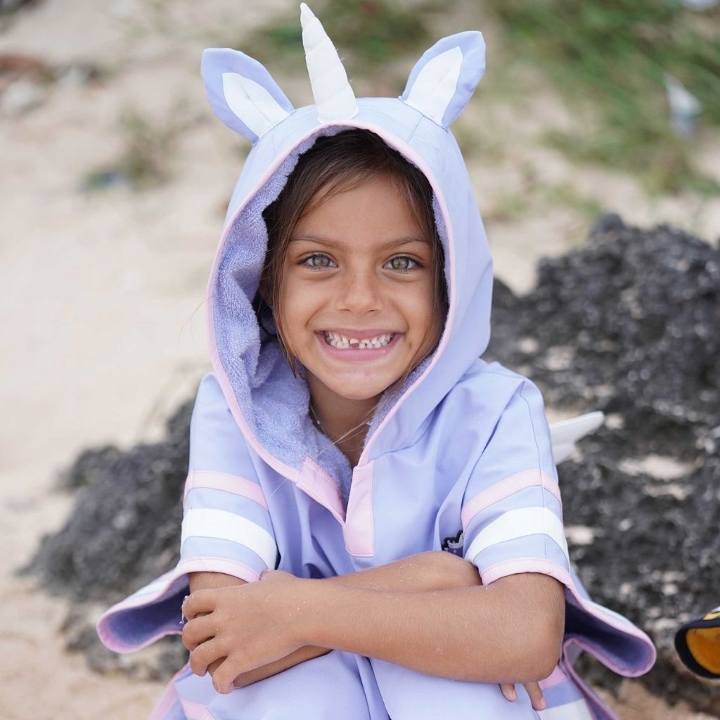 Little girl wearing the Sparkle the Unicorn poncho towel from Roarsome