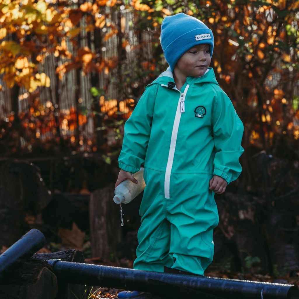 Little boy wearing the Green Spike the Dinosaur Puddlesuit from Roarsome