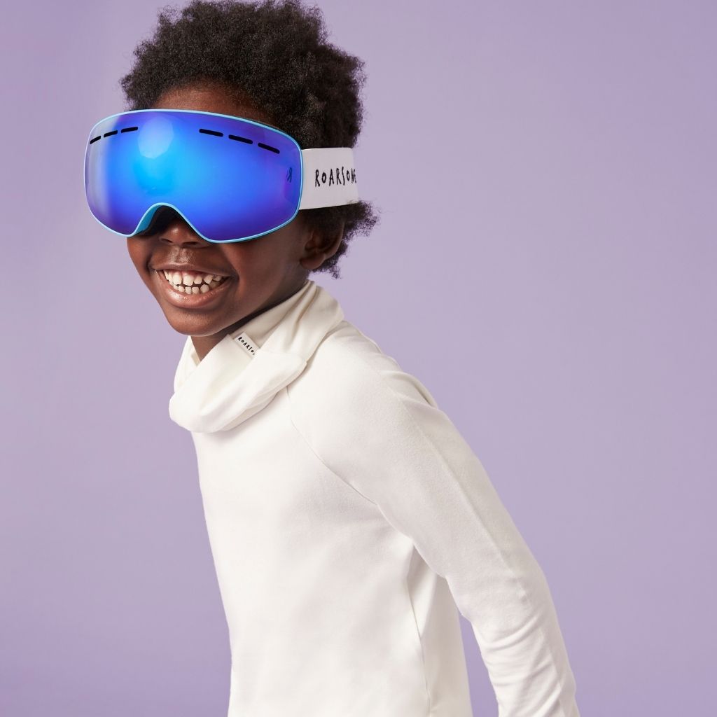 Little boy wearing blue ski goggles with a white frame on a purple background from Roarsome